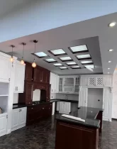 کابینت های سفید قهوه ای و سقف نور پردازی شده با نور سفید آشپزخانه ویلا در سفین کیش